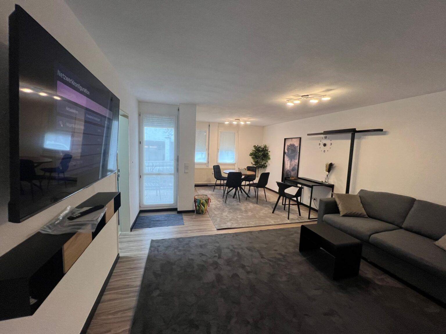 Living area of the apartment with sofa, dining area and desk